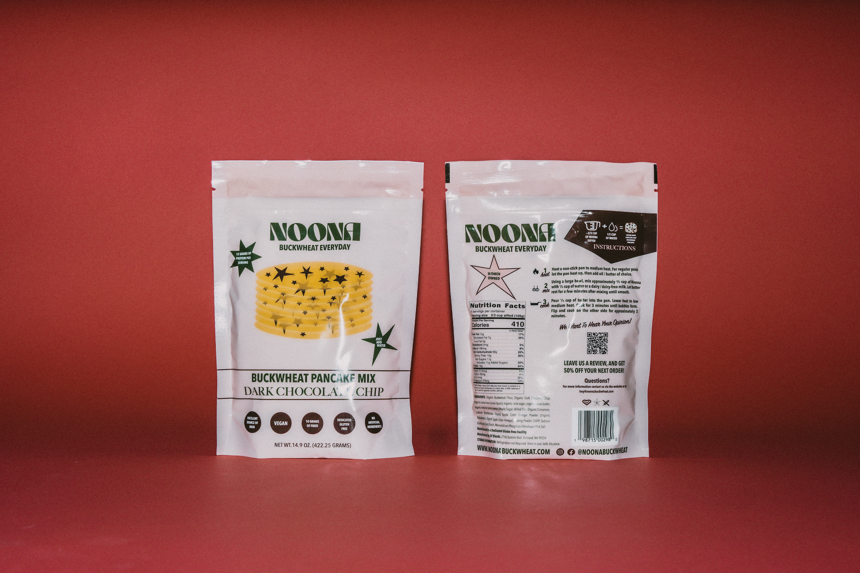 Two packages of Noona's Dark Chocolate Chip Buckwheat Pancake Mix on a bold red background. The front-facing package showcases the Noona logo, product name, and key features like "Gluten-Free," "Vegan," and "High Protein," with an image of chocolate chip pancakes below. The back-facing package displays the nutrient label, ingredient list, and cooking instructions in clear detail.